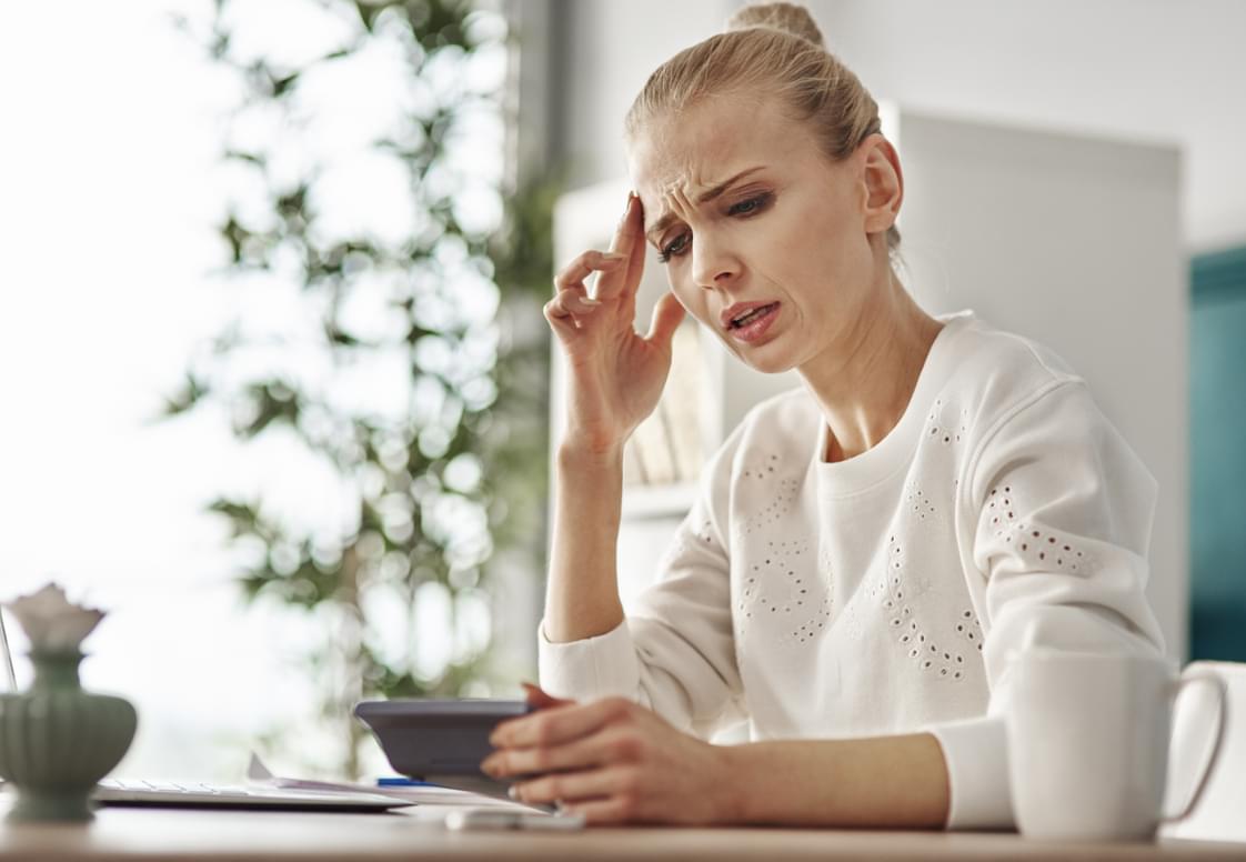 worried-woman-with-calculator-home-office.jpg